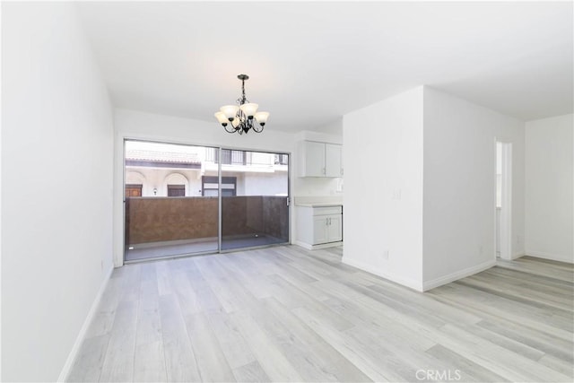 120 S Sierra Madre Blvd Unit 206, Pasadena, CA 91107 - unfurnished living room with a chandelier, light wood-style floors, and baseboards