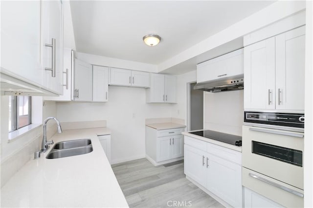 120 S Sierra Madre Blvd Unit 206, Pasadena, CA 91107 - kitchen featuring a sink, white oven, under cabinet range hood, black electric cooktop, and light wood-style floors