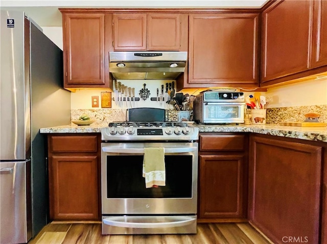 921 Piru Way, Frazier Park, CA 93225 - kitchen with under cabinet range hood, light wood finished floors, stainless steel appliances, and light stone counters