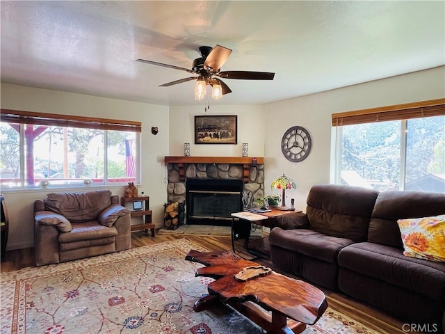 921 Piru Way, Frazier Park, CA 93225 - living room featuring healthy amount of natural light, wood finished floors, a ceiling fan, and a stone fireplace