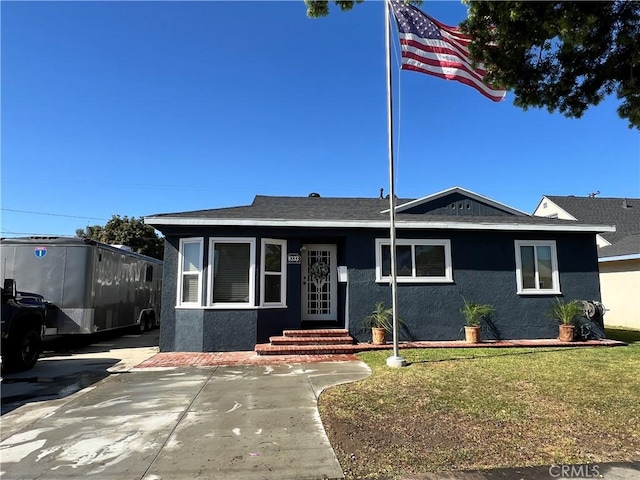 view of front of house with stucco siding and a front lawn