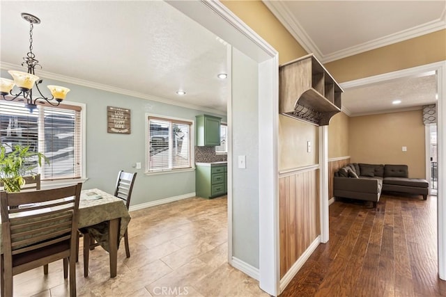 dining area with a chandelier, ornamental molding, and baseboards