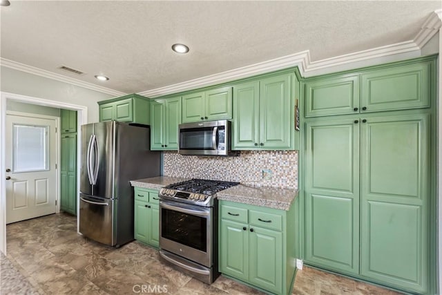kitchen with appliances with stainless steel finishes, crown molding, green cabinetry, tasteful backsplash, and a textured ceiling