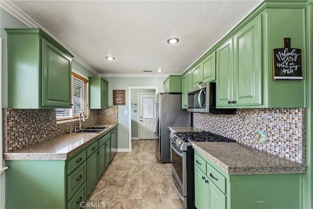 kitchen featuring appliances with stainless steel finishes, a sink, crown molding, baseboards, and decorative backsplash