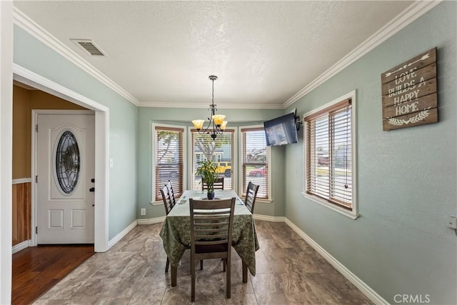 dining room with a chandelier, plenty of natural light, a textured ceiling, ornamental molding, and baseboards