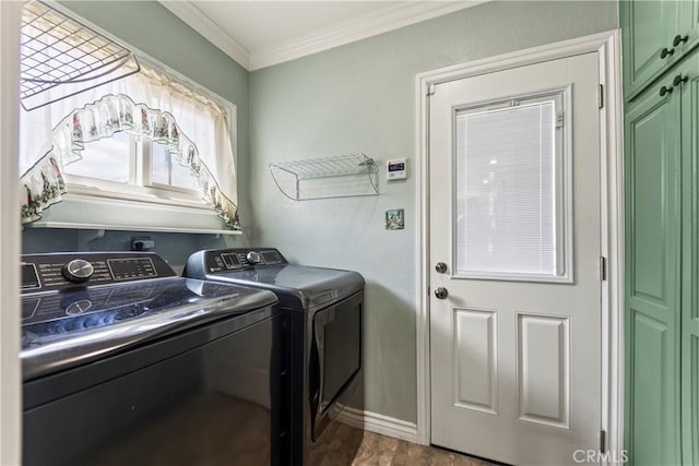 washroom featuring washer and dryer, cabinet space, ornamental molding, baseboards, and wood finished floors