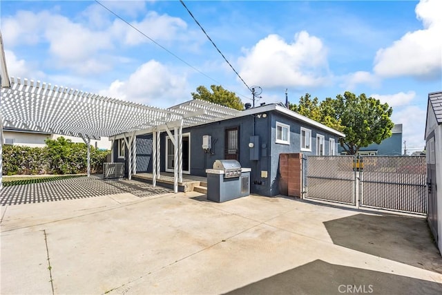 rear view of house featuring a gate, a pergola, a patio area, stucco siding, and fence