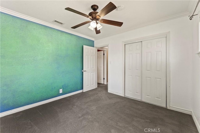 unfurnished bedroom with crown molding, dark carpet, baseboards, a closet, and ceiling fan