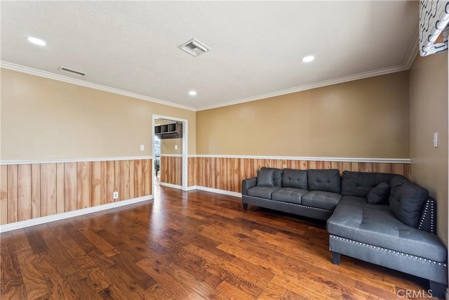 living room with wood finished floors, ornamental molding, a wainscoted wall, recessed lighting, and baseboards
