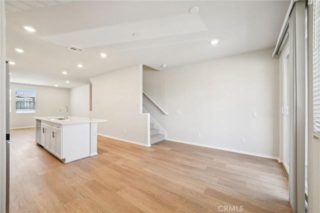 219 Aurora Ln, Pomona, CA 91767 - kitchen with light wood-type flooring, recessed lighting, dishwasher, a center island with sink, and light countertops