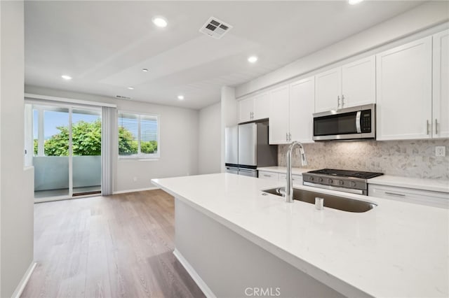 219 Aurora Ln, Pomona, CA 91767 - kitchen with appliances with stainless steel finishes, a sink, white cabinets, decorative backsplash, and recessed lighting