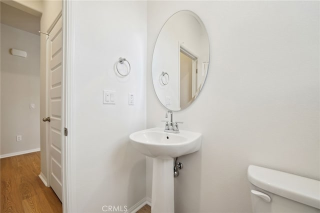 219 Aurora Ln, Pomona, CA 91767 - half bathroom with toilet, wood finished floors, and baseboards