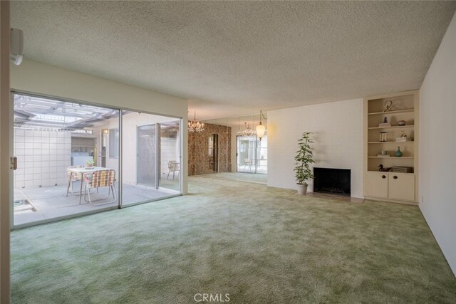 999 E Valley Blvd Unit 44, Alhambra, CA 91801 - unfurnished living room with a chandelier, carpet floors, a fireplace, a textured ceiling, and built in shelves