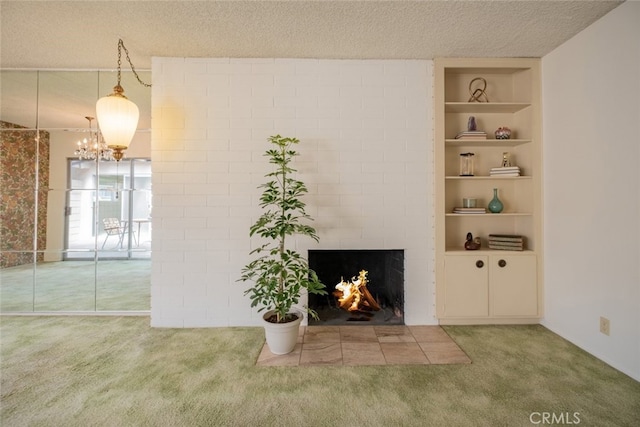 999 E Valley Blvd Unit 44, Alhambra, CA 91801 - unfurnished living room featuring carpet flooring, built in shelves, a textured ceiling, a brick fireplace, and a chandelier