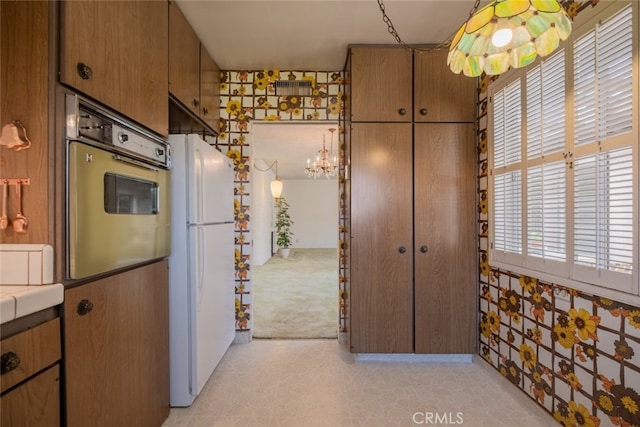 999 E Valley Blvd Unit 44, Alhambra, CA 91801 - kitchen featuring oven, freestanding refrigerator, a chandelier, and brown cabinetry