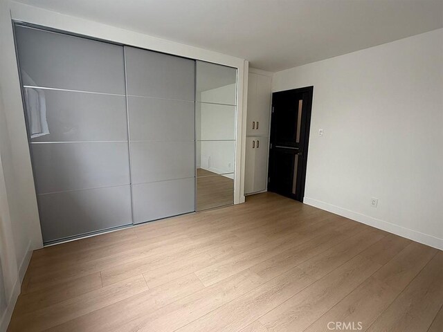 960 Larrabee St Unit 120, West Hollywood, CA 90069 - unfurnished bedroom with wood finished floors, a closet, and baseboards