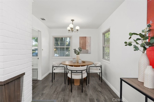 dining room with a chandelier, wood finished floors, visible vents, and baseboards