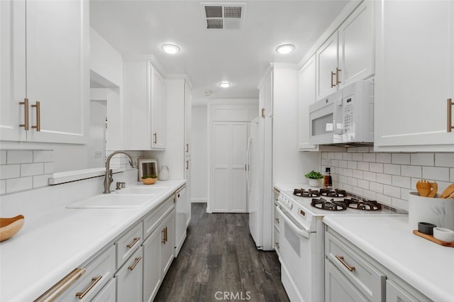 kitchen featuring a sink, white appliances, light countertops, white cabinetry, and visible vents