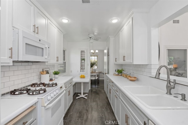 kitchen featuring white cabinets, dark wood-type flooring, a sink, and white appliances
