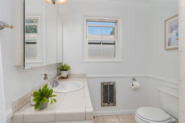 bathroom with toilet, baseboards, heating unit, tile patterned flooring, and vanity