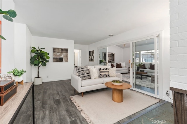 living area featuring baseboards, wood finished floors, and visible vents