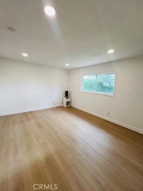 unfurnished room with wood finished floors, recessed lighting, and baseboards