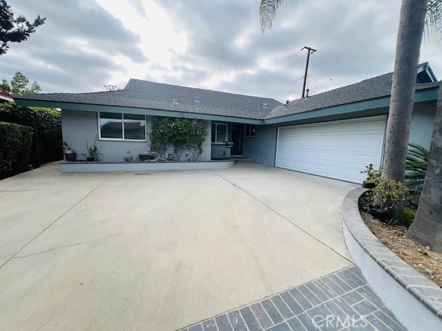 single story home with concrete driveway, a garage, and stucco siding