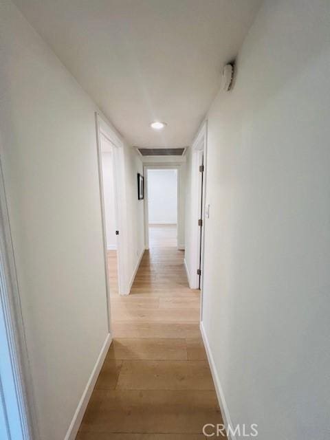 hallway featuring baseboards, visible vents, light wood-style flooring, and recessed lighting