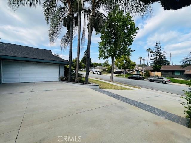 exterior space featuring concrete driveway and a residential view