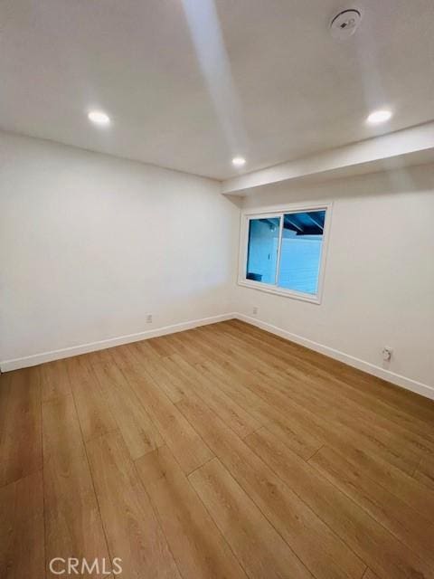 empty room with wood-type flooring, recessed lighting, and baseboards