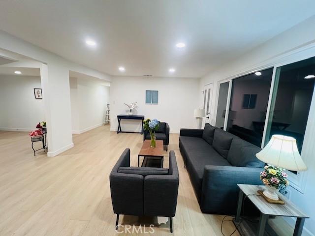 living area with baseboards, recessed lighting, and light wood finished floors