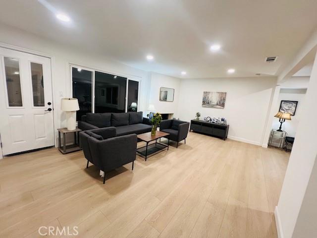 living area with visible vents, recessed lighting, light wood finished floors, and baseboards