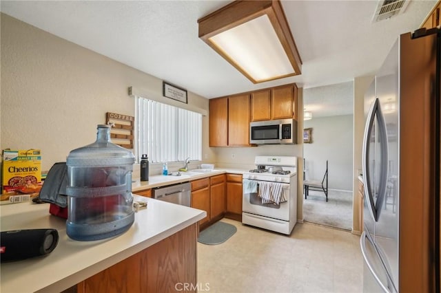 447 Westminister Dr, San Jacinto, CA 92583 - kitchen with appliances with stainless steel finishes, a sink, light countertops, brown cabinets, and light floors
