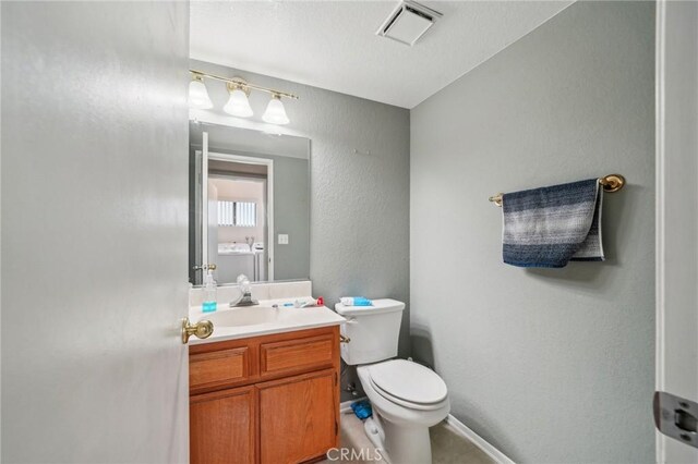 447 Westminister Dr, San Jacinto, CA 92583 - bathroom with toilet, vanity, and baseboards