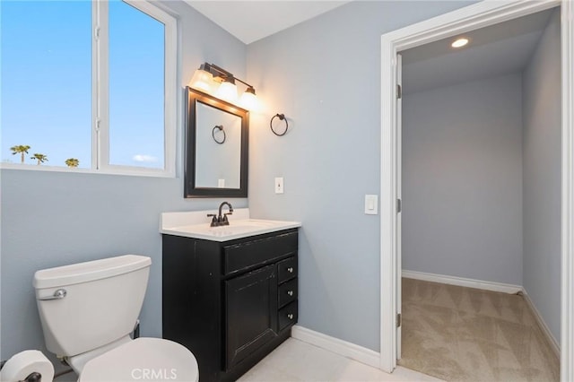 bathroom featuring baseboards, vanity, toilet, and recessed lighting