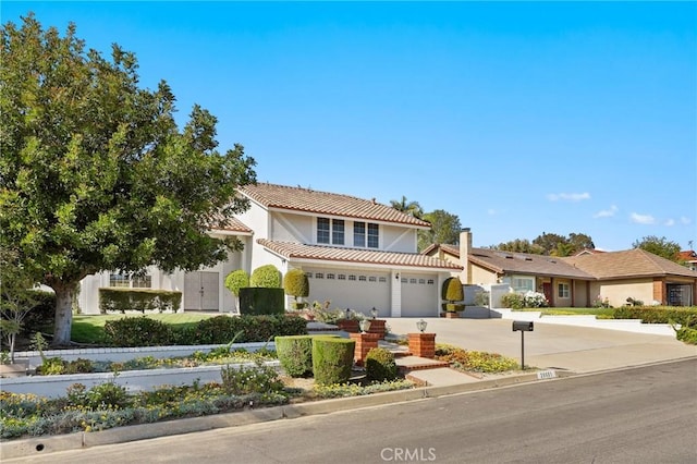 view of front of home featuring a tile roof, driveway, stucco siding, and a garage