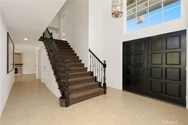 foyer entrance featuring stairway, light tile patterned flooring, baseboards, a chandelier, and recessed lighting