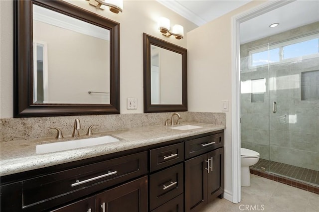full bath with a stall shower, toilet, double vanity, and tile patterned floors