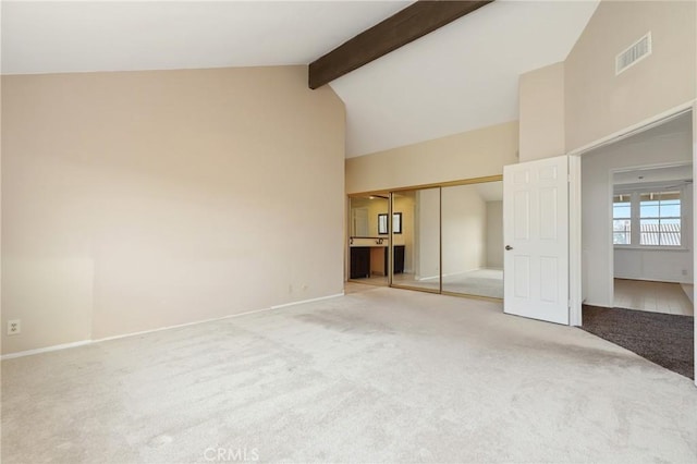 unfurnished bedroom with beamed ceiling, carpet, a closet, baseboards, and high vaulted ceiling