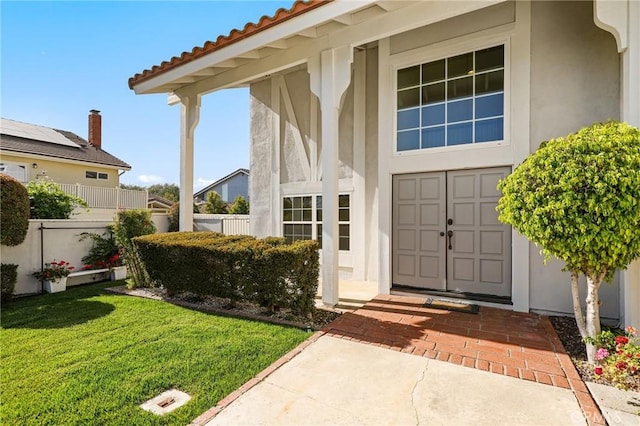 entrance to property with stucco siding and a tiled roof
