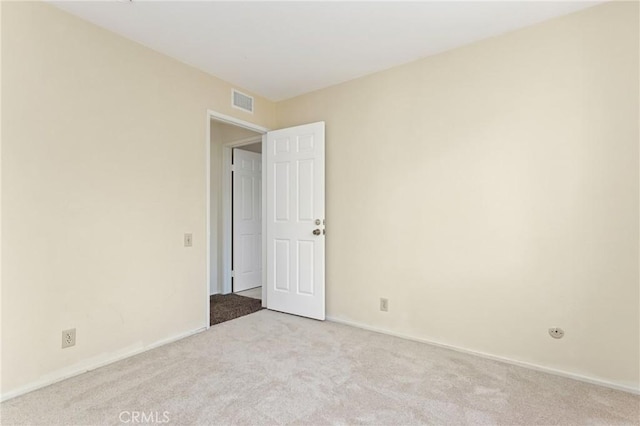carpeted empty room featuring baseboards