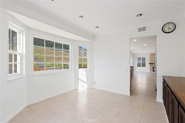 empty room with plenty of natural light, ornamental molding, baseboards, light tile patterned floors, and recessed lighting