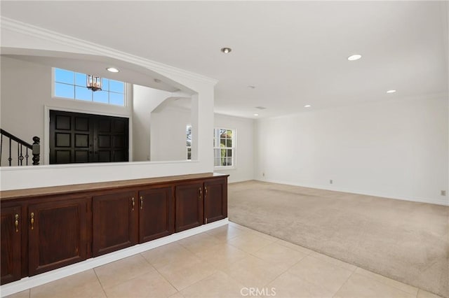 foyer featuring light colored carpet, recessed lighting, baseboards, crown molding, and stairway