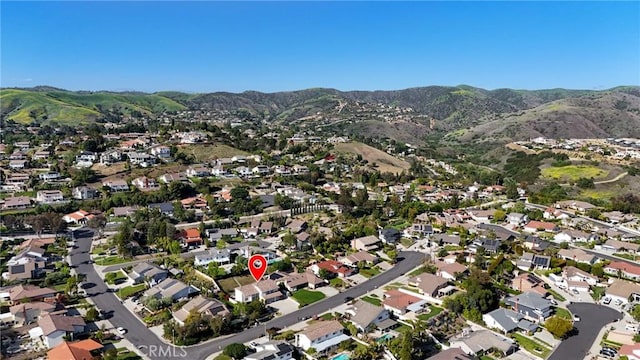 aerial view of property's location with a mountain backdrop and nearby suburban area