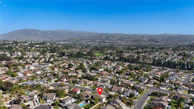 aerial view of property's location with nearby suburban area and a mountainous background
