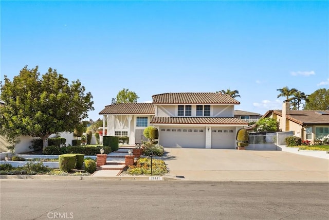 view of front of property featuring concrete driveway, a garage, stucco siding, fence, and a tiled roof