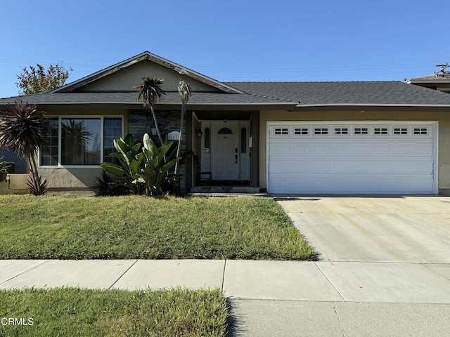 ranch-style home with a garage, concrete driveway, a front yard, stucco siding, and a shingled roof