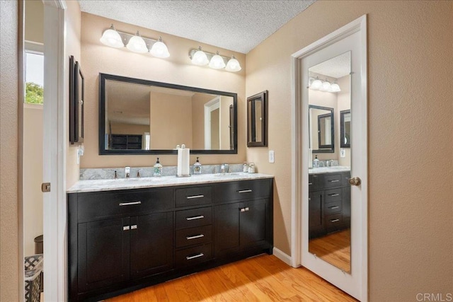 1943 Belmore Ct, El Cajon, CA 92020 - full bath with double vanity, a sink, a textured ceiling, and wood finished floors