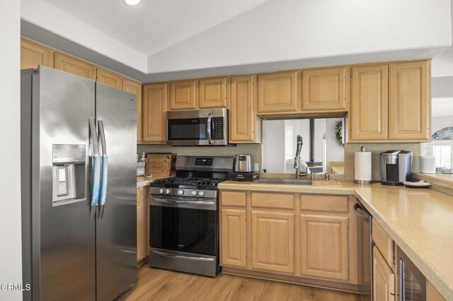 5270 W Wooley Rd, Oxnard, CA 93035 - kitchen with appliances with stainless steel finishes, vaulted ceiling, light countertops, light wood-type flooring, and beverage cooler
