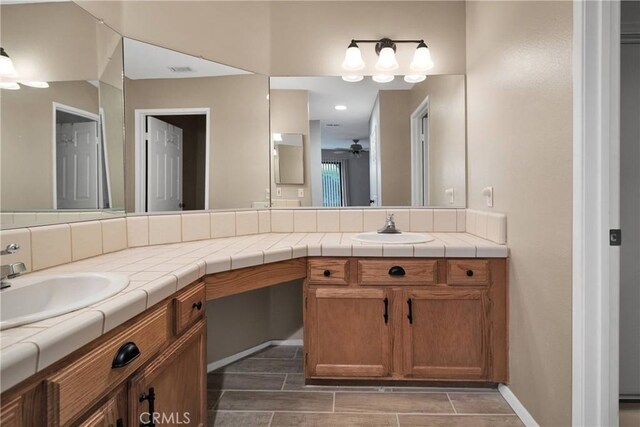 full bathroom with ceiling fan, baseboards, vanity, and visible vents